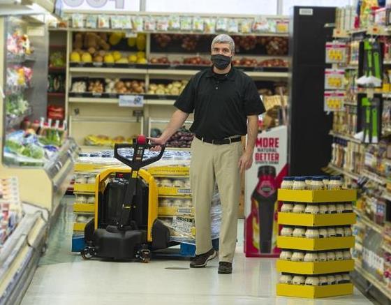 Lift-Rite Edge pallet truck being used in grocery store to restock shelves. 